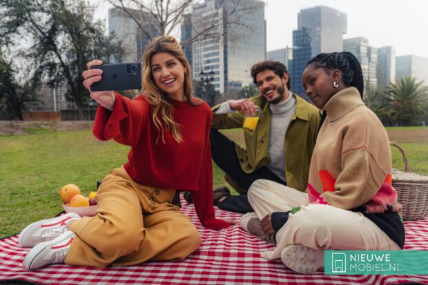 Menschen, die mit dem Motorola edge 30 Ultra in einem Park sitzen und ein Foto machen