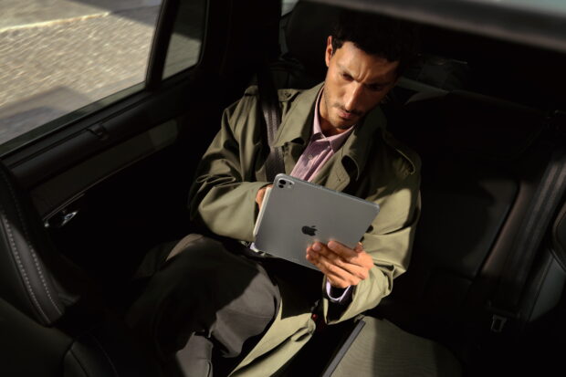 Man working on Apple iPad Pro 2025 in car